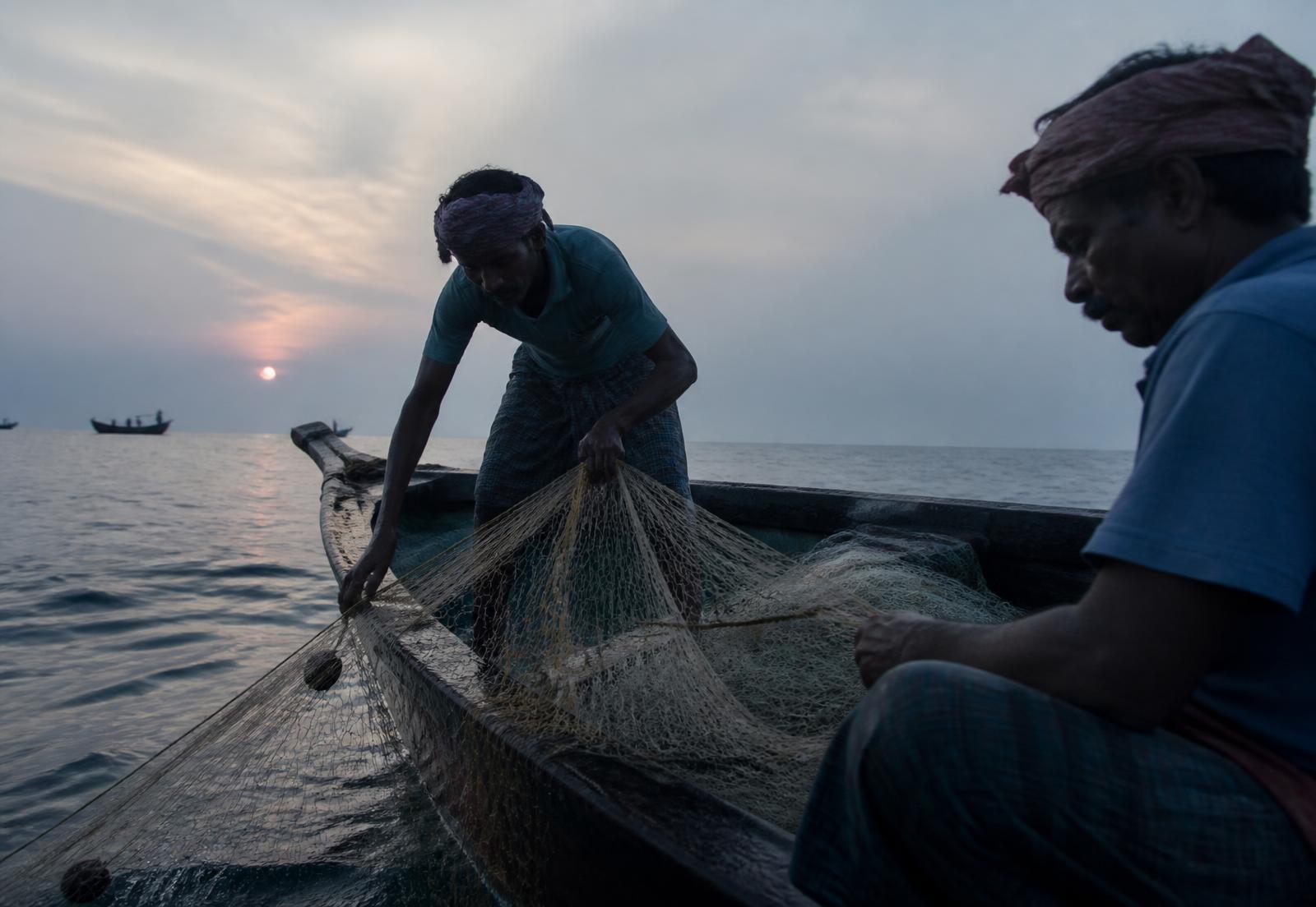 Fishermen working a net at first light